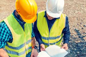 Two workers at a construction job looking at a site plan